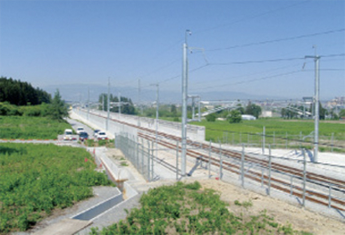 北海道新幹線万太郎路盤他工事の施工現場。線路と架線柱、コンクリート構造物が写る。